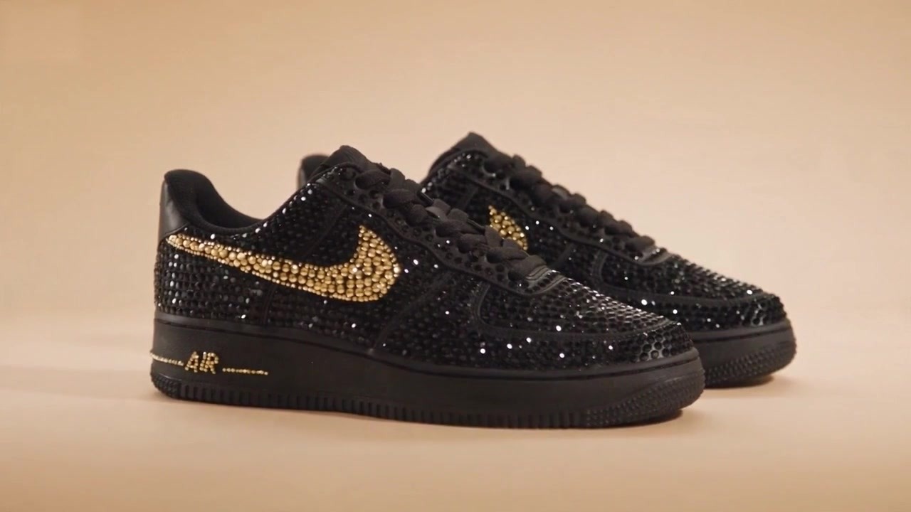 Custom black sneaker pair with a hand-set crystal finish and a gold swoosh