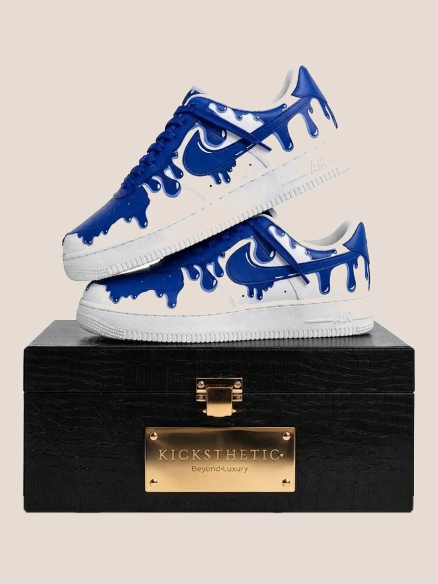 Kicksthetic bespoke sneaker pair with a hand-painted blue drip design, resting on its signature black and gold box
